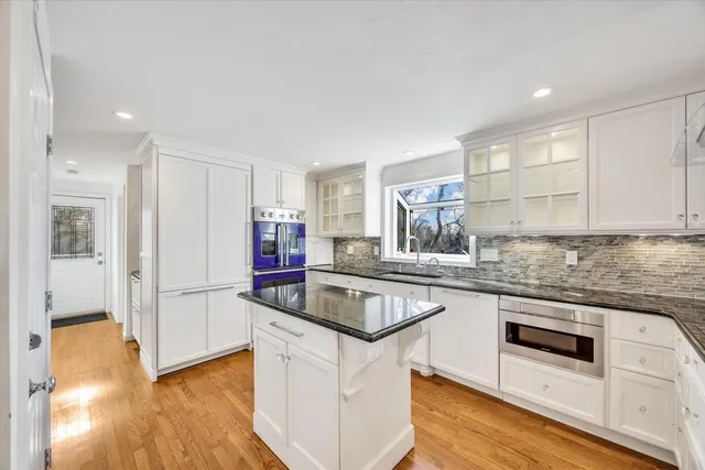 a kitchen with stainless steel appliances granite countertop a sink and a refrigerator
