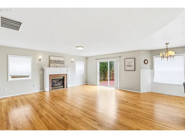a view of empty room with wooden floor and fireplace