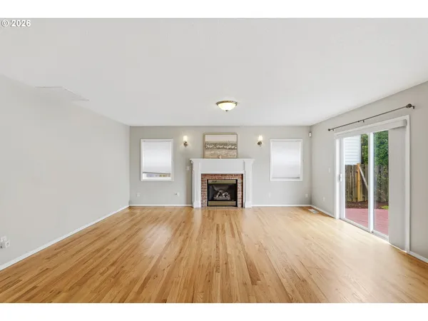 a view of an empty room with a window and fireplace
