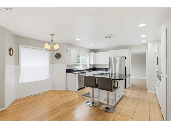 a open kitchen with stainless steel appliances kitchen island granite countertop a refrigerator and a sink