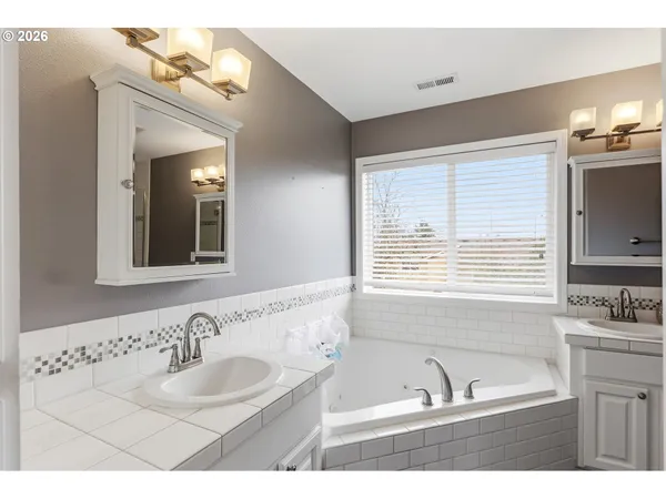 a bathroom with a tub sink and mirror