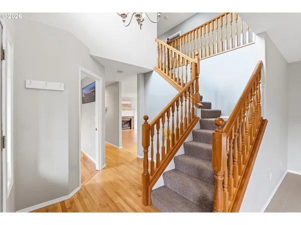 a view of a hallway with wooden floor and staircase