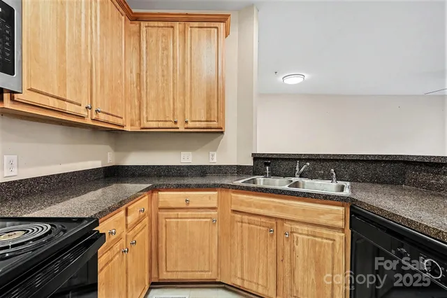 a kitchen with granite countertop a sink stove and cabinets