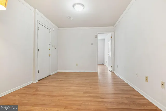 a view of an empty room with wooden floor