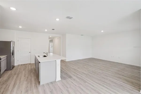 an empty room with wooden floor and a fireplace