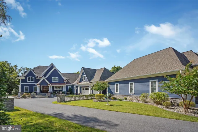 a front view of a house with a yard and potted plants