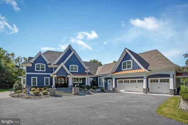 a front view of a house with yard and parking