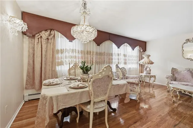 a view of a dining room with furniture a chandelier and wooden floor