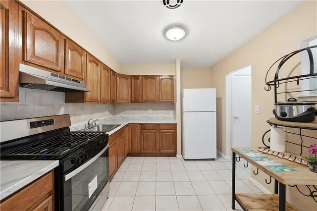 a kitchen with a stove a refrigerator and a sink