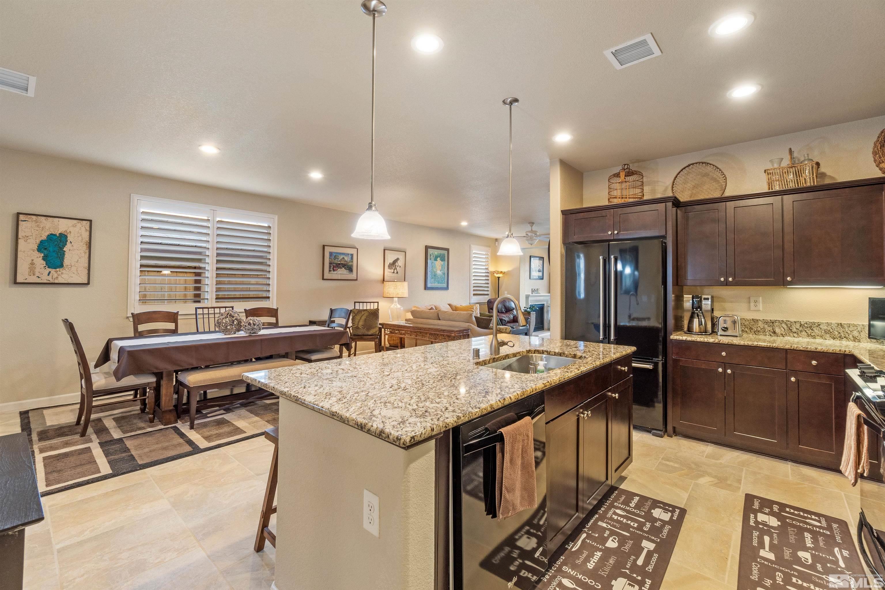 9224 Sassafras Trail Reno, NV 89523 - Photo 6 of 36 a kitchen with a stove a counter space dining table and chairs