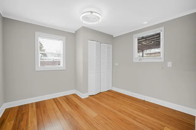 a view of a room with wooden floor and windows
