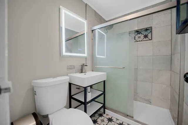 a bathroom with a sink toilet and a mirror