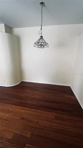 a view of wooden floor and a chandelier fan in a room