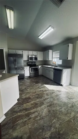 a kitchen with stainless steel appliances wooden cabinets and stove top oven