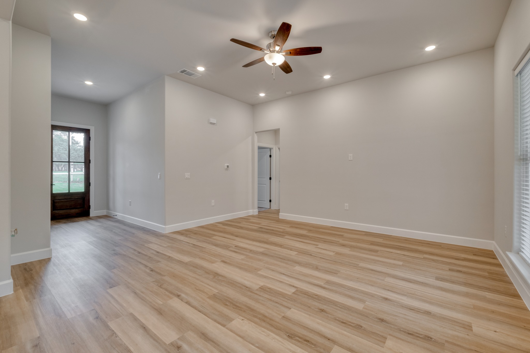 116 Pine Point Cove Elgin, TX 78621 - Photo 7 of 27 Spacious room featuring wood-finish flooring, recessed lighting, a ceiling fan, and a wood-paneled door with glass inserts