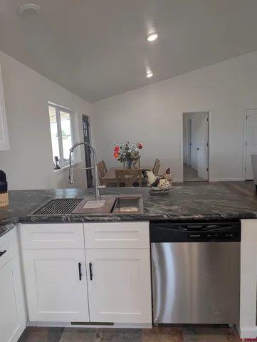 a kitchen with granite countertop a sink and cabinets