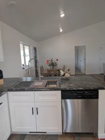 a kitchen with granite countertop a sink and cabinets
