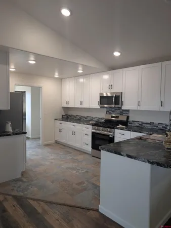 a kitchen with stainless steel appliances granite countertop a stove top oven a sink and a granite counter tops