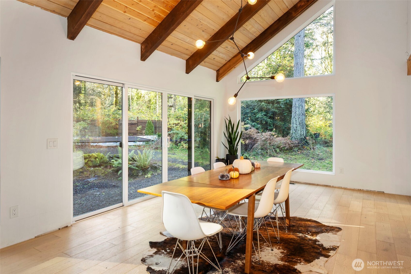 16455 Agate Point Road Northeast Bainbridge Island, WA 98110 - Photo 10 of 26 a view of a dining room with furniture wooden floor and a potted plant