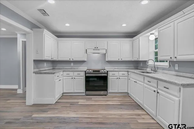 a kitchen with granite countertop white cabinets and stainless steel appliances