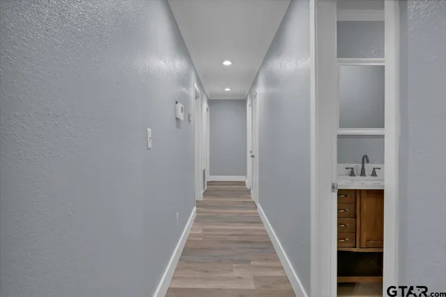 a view of a hallway with wooden floor and staircase