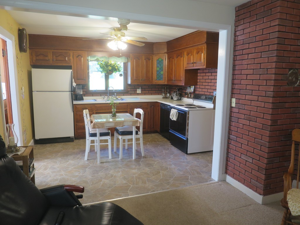 2144 Palmer Road Three Rivers, MA 01080 - Photo 5 of 22 a kitchen with a dining table chairs and refrigerator