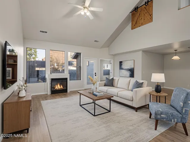 an empty room with windows and chandelier fan