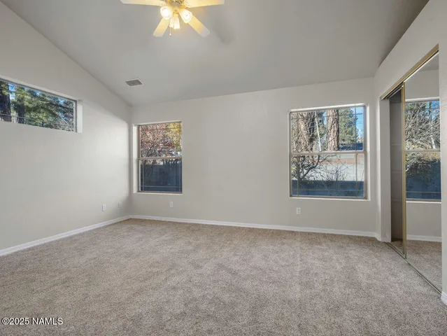 a spacious bedroom with a bed and a chandelier