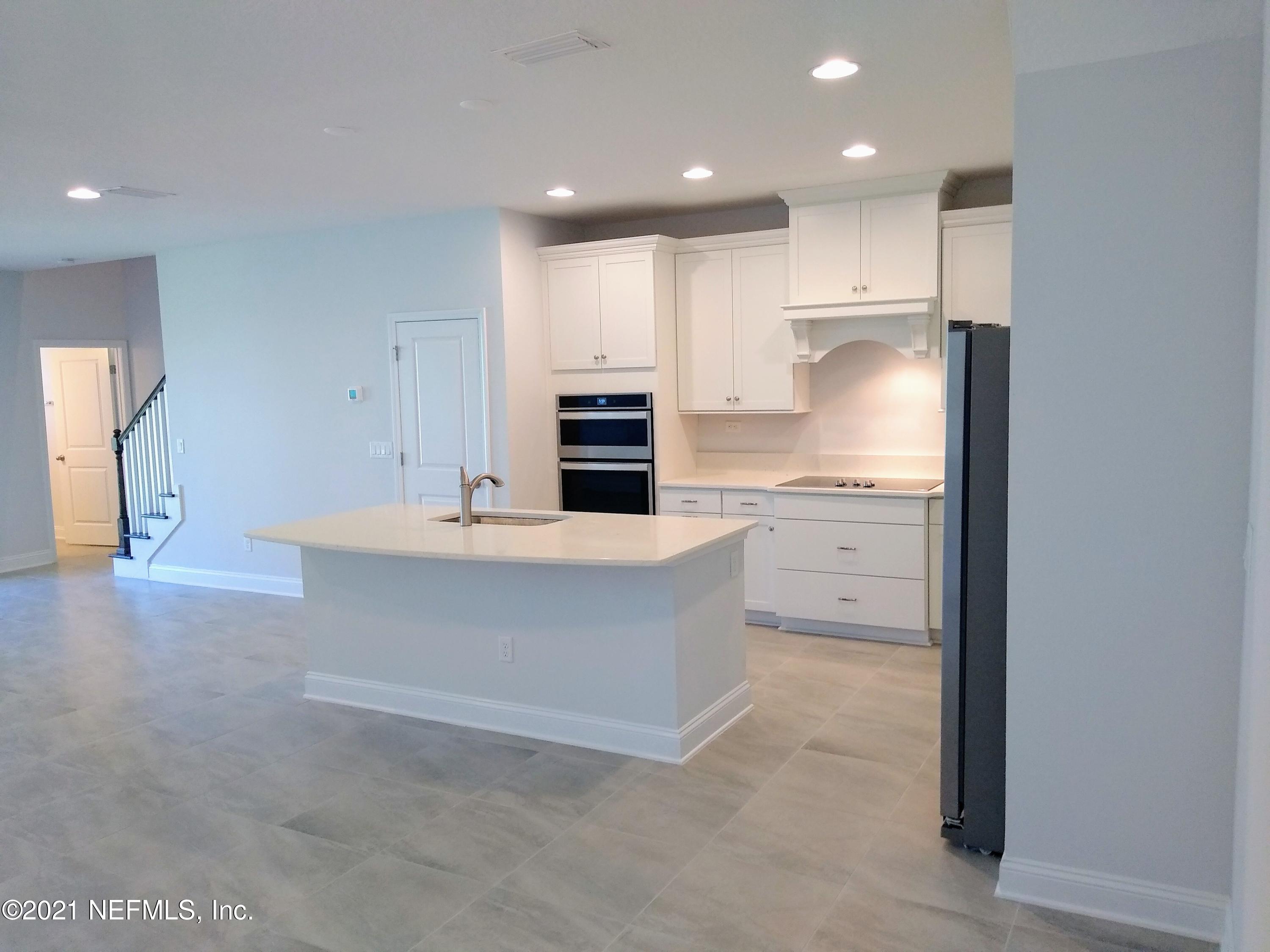 319 Charlie Way St. Augustine, FL 32095 - Photo 2 of 36 a kitchen with kitchen island a sink stainless steel appliances and cabinets