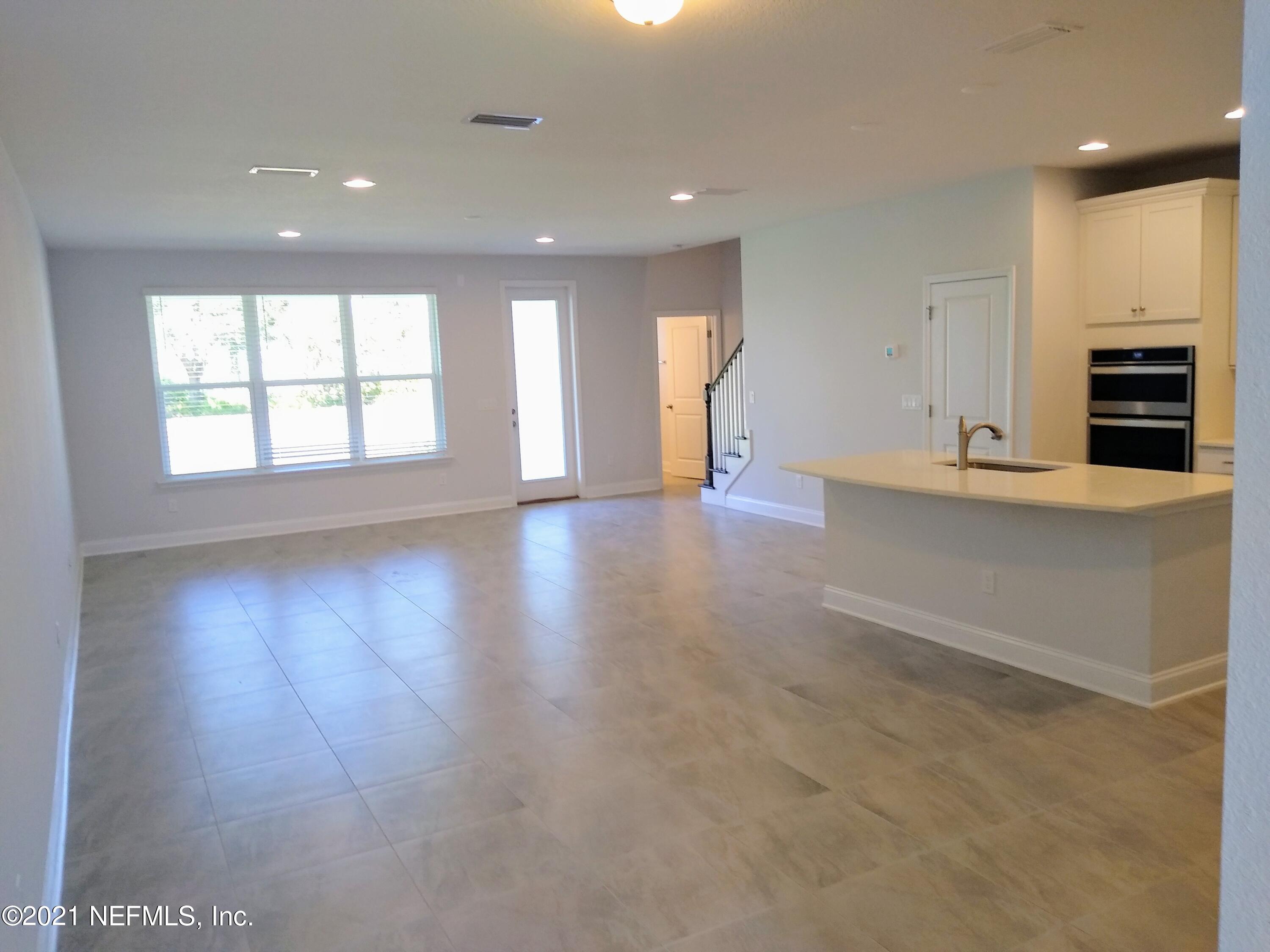 319 Charlie Way St. Augustine, FL 32095 - Photo 3 of 36 an empty room with wooden floor and windows