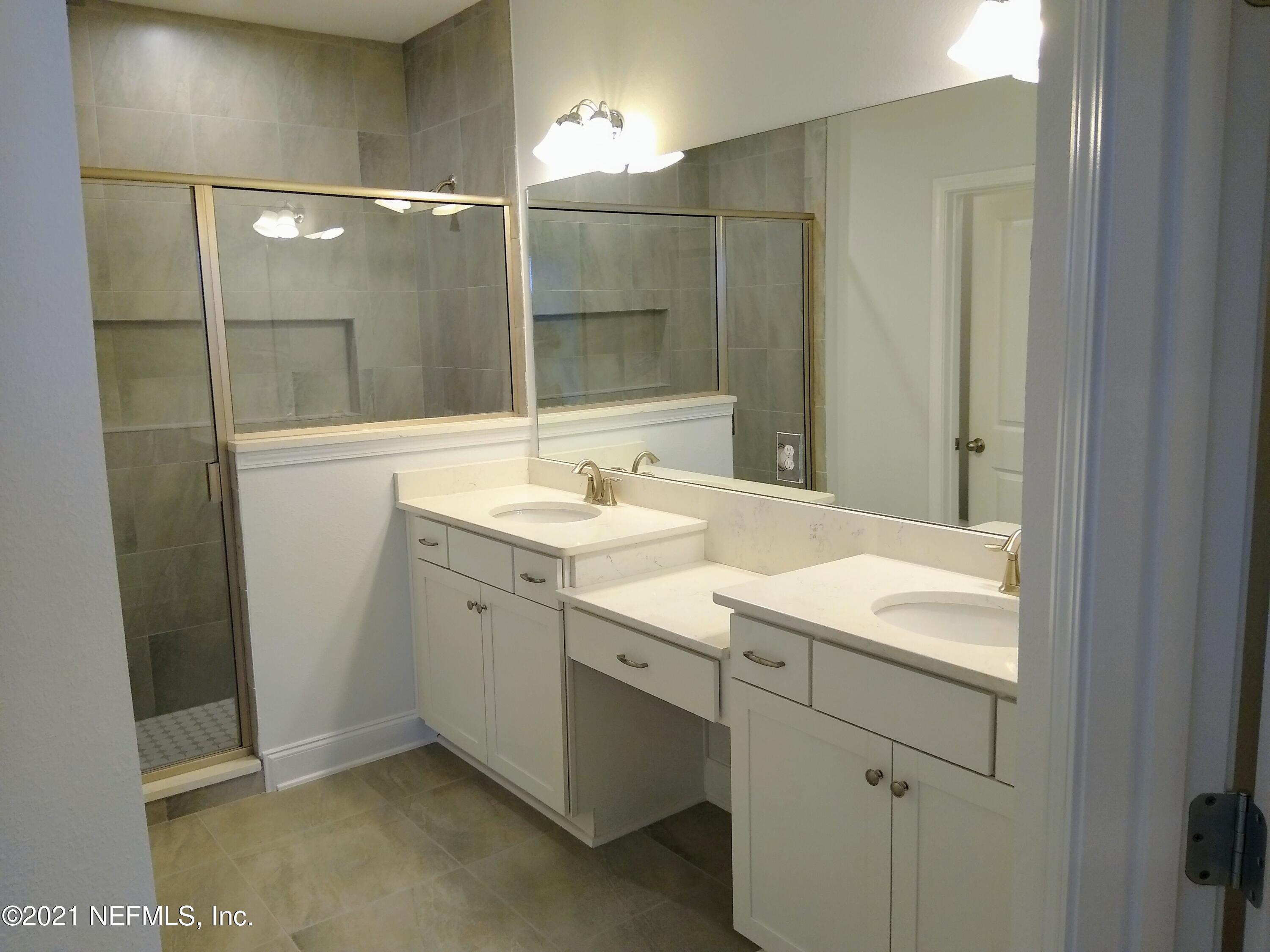 319 Charlie Way St. Augustine, FL 32095 - Photo 8 of 36 a bathroom with a sink vanity and shower