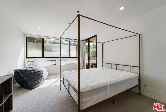 a bedroom with a large bed and wooden floor
