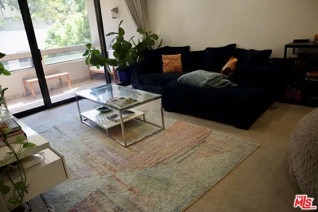 a living room with furniture and a floor to ceiling window