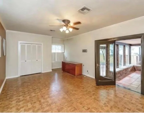 a view of a big room with wooden floor and a window