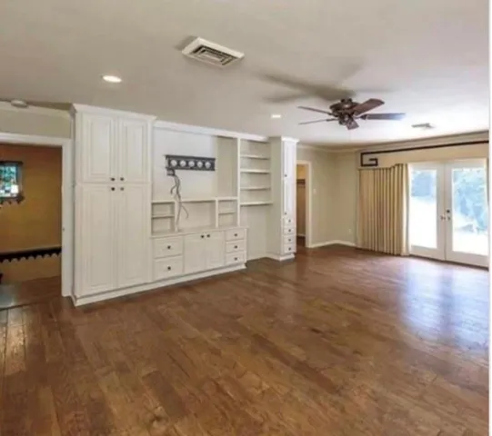 a bathroom with a granite countertop double vanity and a mirror