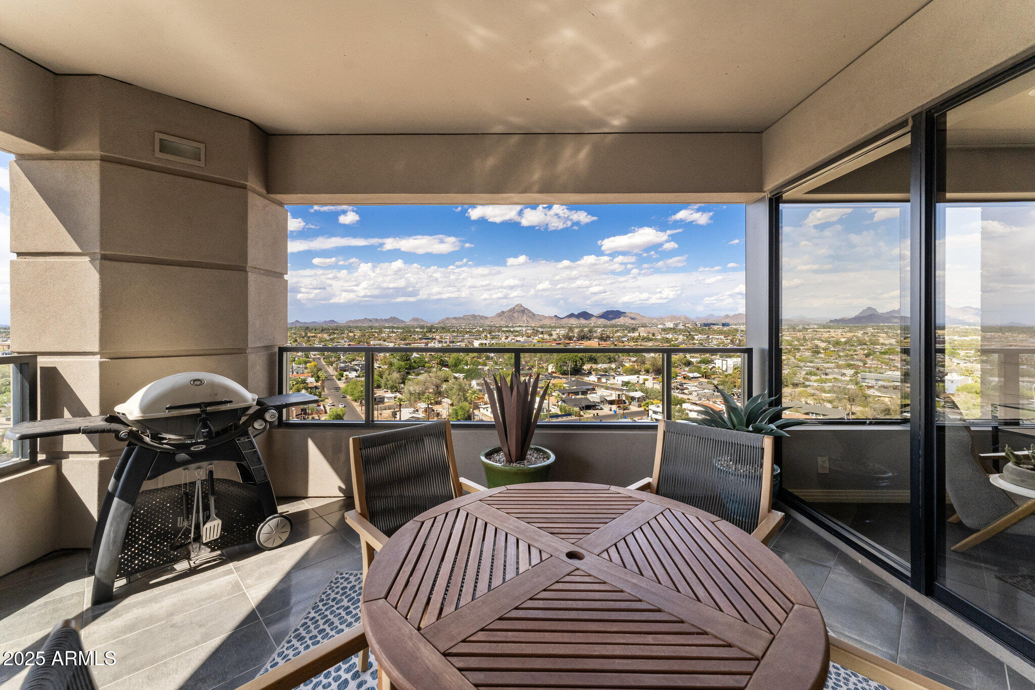 1040 East Osborn Road, Unit 1103 Phoenix, AZ 85014 - Photo 12 of 49 a bedroom with a bed a city view and large windows