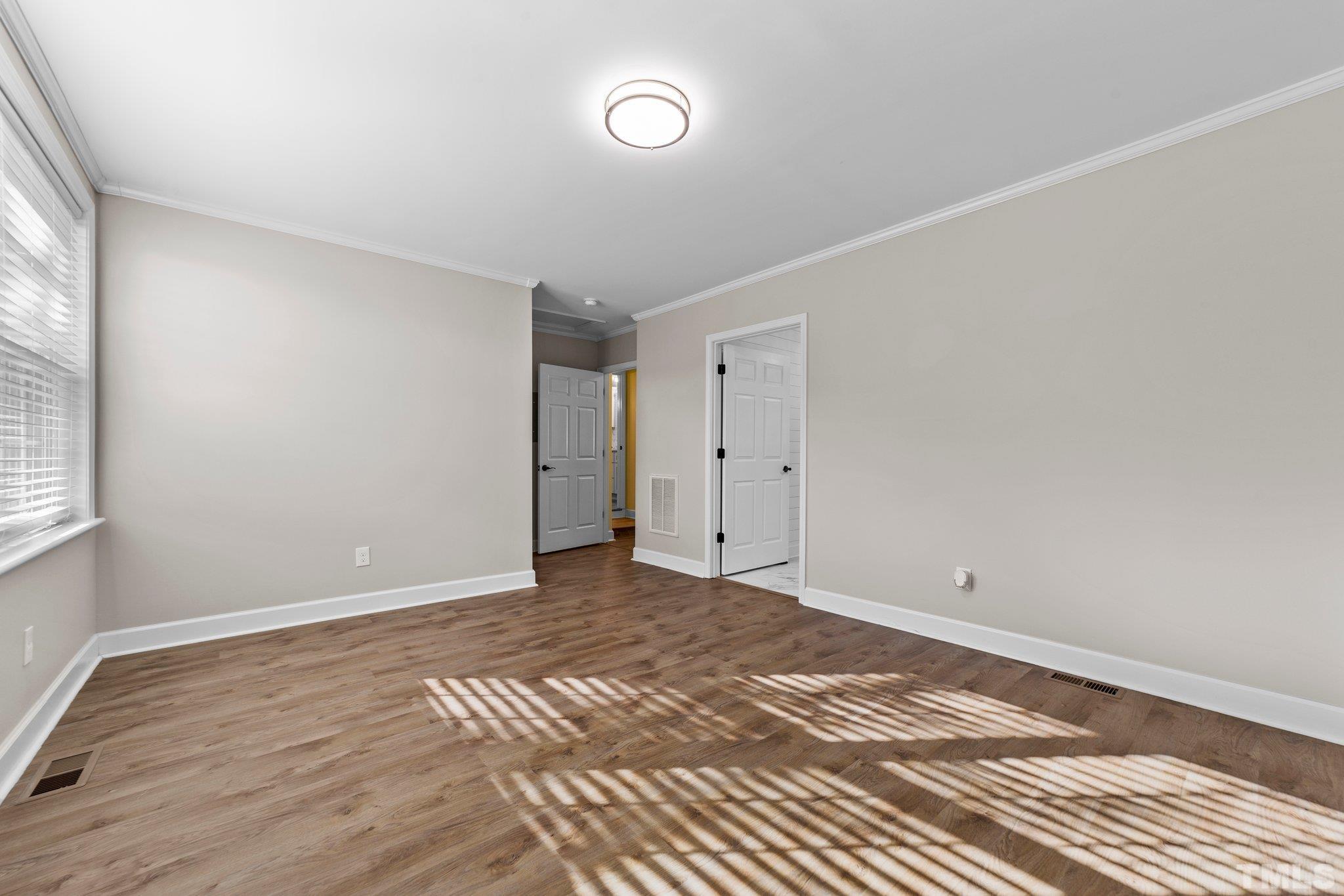 774 Abbott Road Henderson, NC 27537 - Photo 20 of 41 a view of an empty room with wooden floor and a window