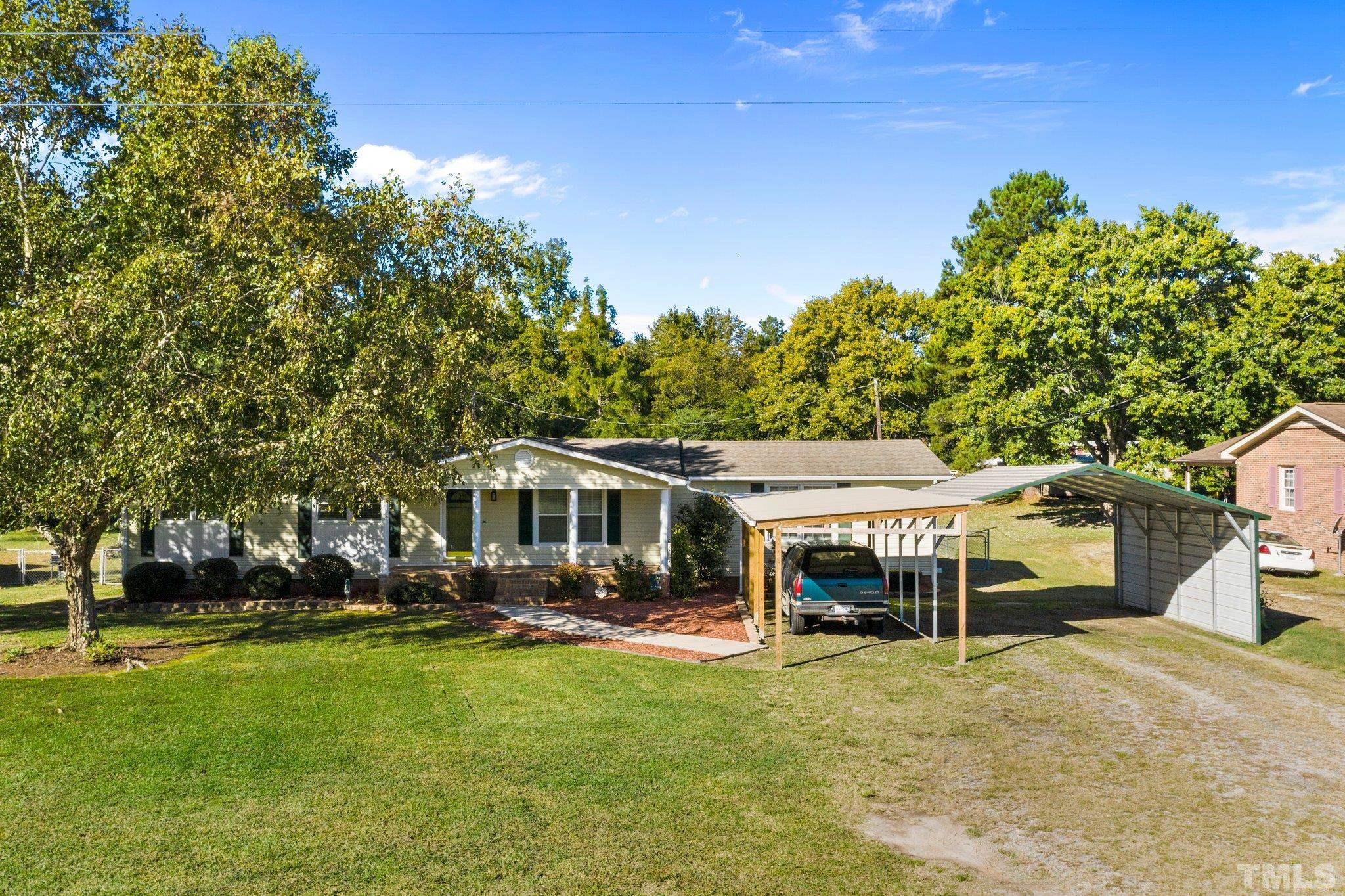 774 Abbott Road Henderson, NC 27537 - Photo 2 of 41 a view of a house with a yard table and chairs