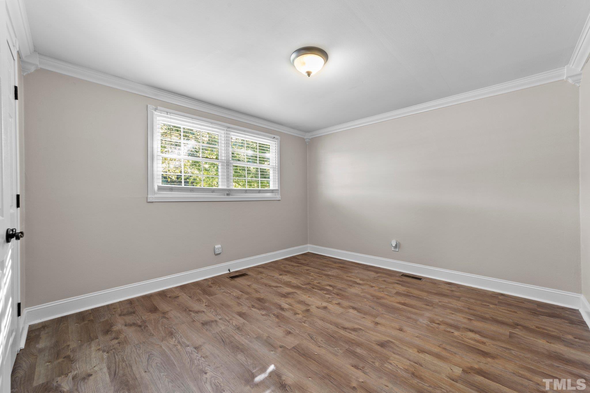 774 Abbott Road Henderson, NC 27537 - Photo 22 of 41 an empty room with wooden floor and windows