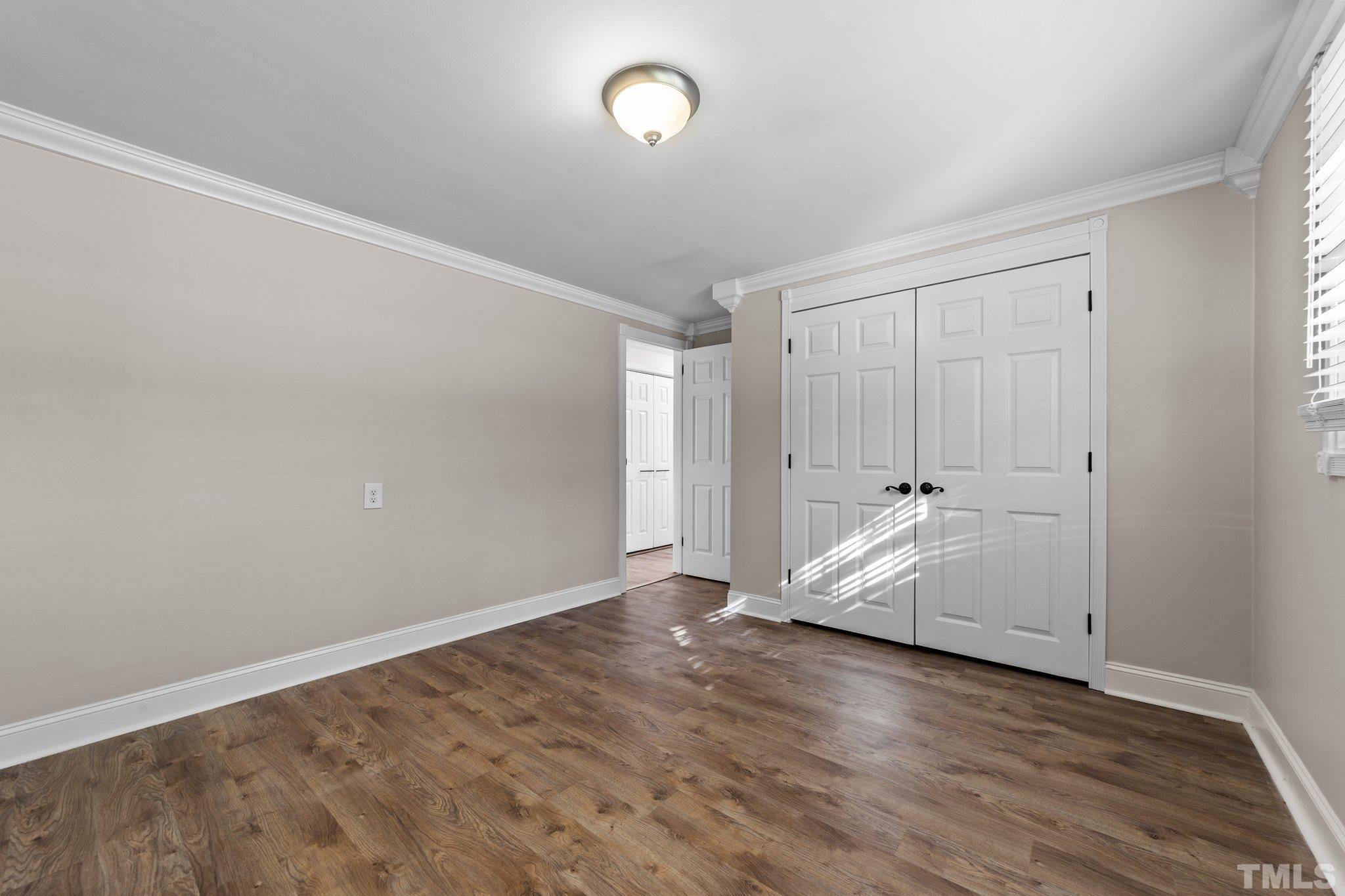 774 Abbott Road Henderson, NC 27537 - Photo 23 of 41 an empty room with wooden floor and window