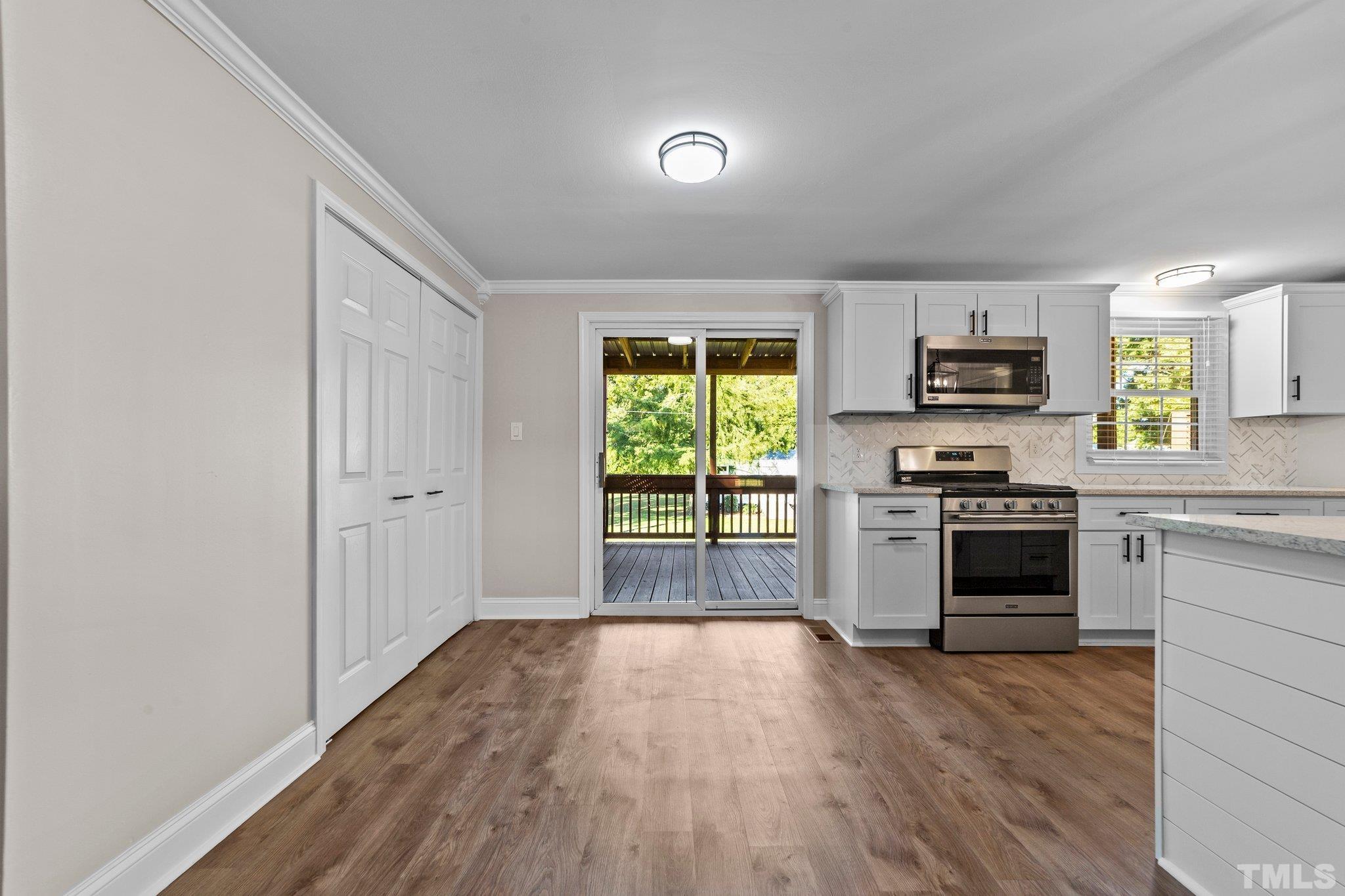 774 Abbott Road Henderson, NC 27537 - Photo 9 of 41 a kitchen with granite countertop a stove top oven a sink and a microwave