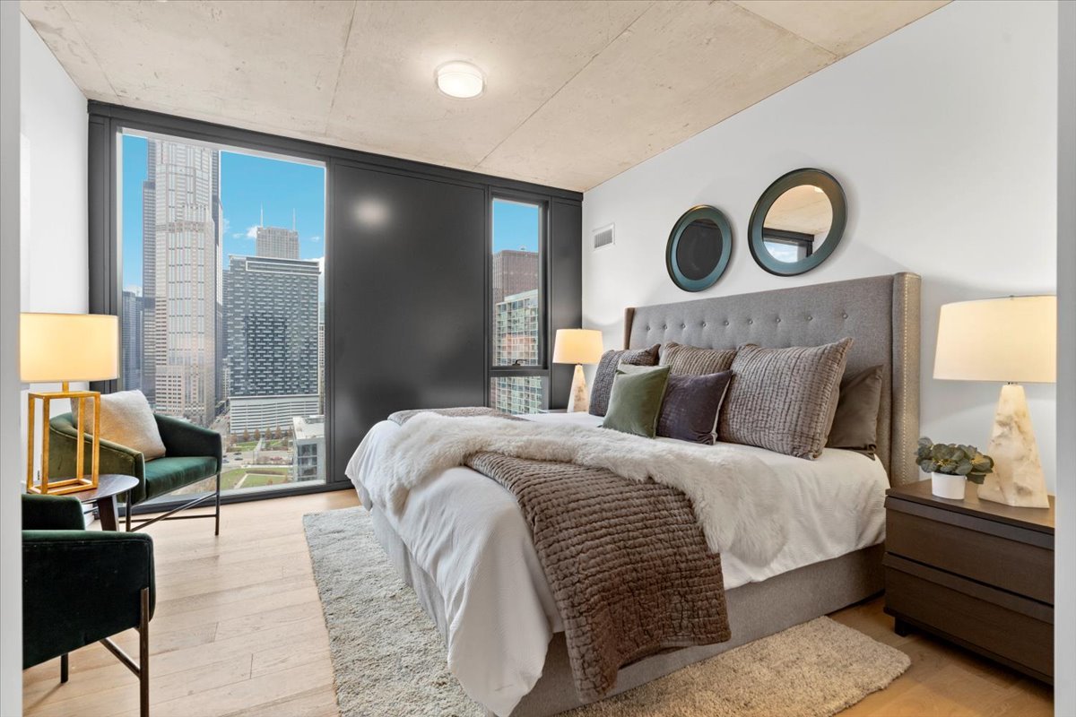 234 West Polk Street, Unit 3612 Chicago, IL 60607 - Photo 13 of 39 a bedroom with double bed and a chandelier