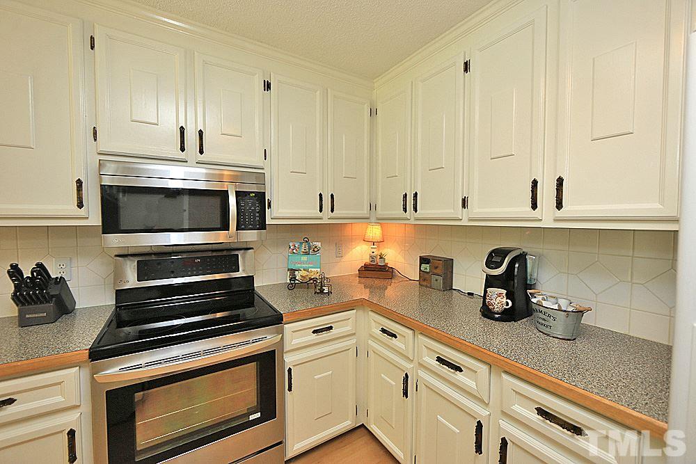 12521 Ghoston Road Wake Forest, NC 27587 - Photo 8 of 30 a kitchen with granite countertop white cabinets and white appliances