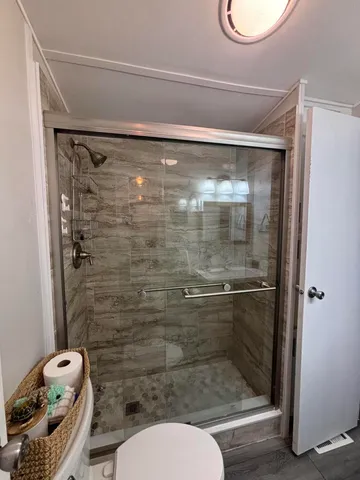 a bathroom with a toilet and a shower