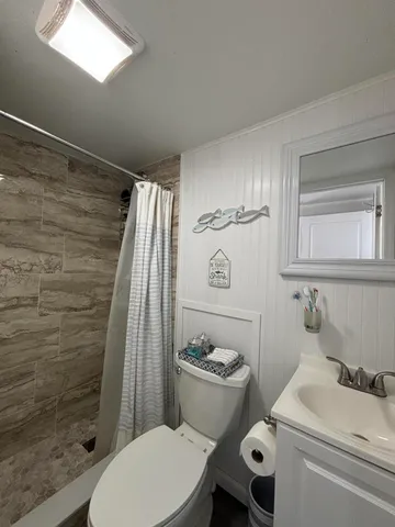 a bathroom with a sink a toilet and shower curtain