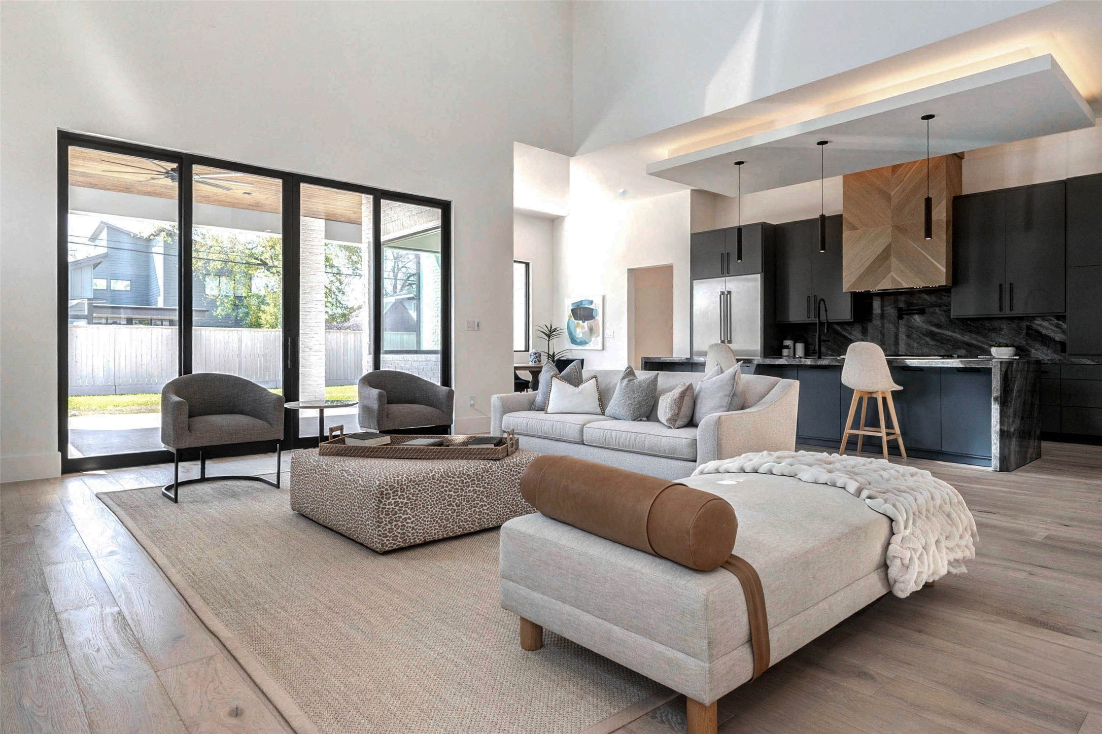 207 West 33rd Street Houston, TX 77018 - Photo 2 of 50 Open-concept living area filled with natural light from oversized black-framed windows and sliding glass doors, creating a seamless indoor-outdoor connection.