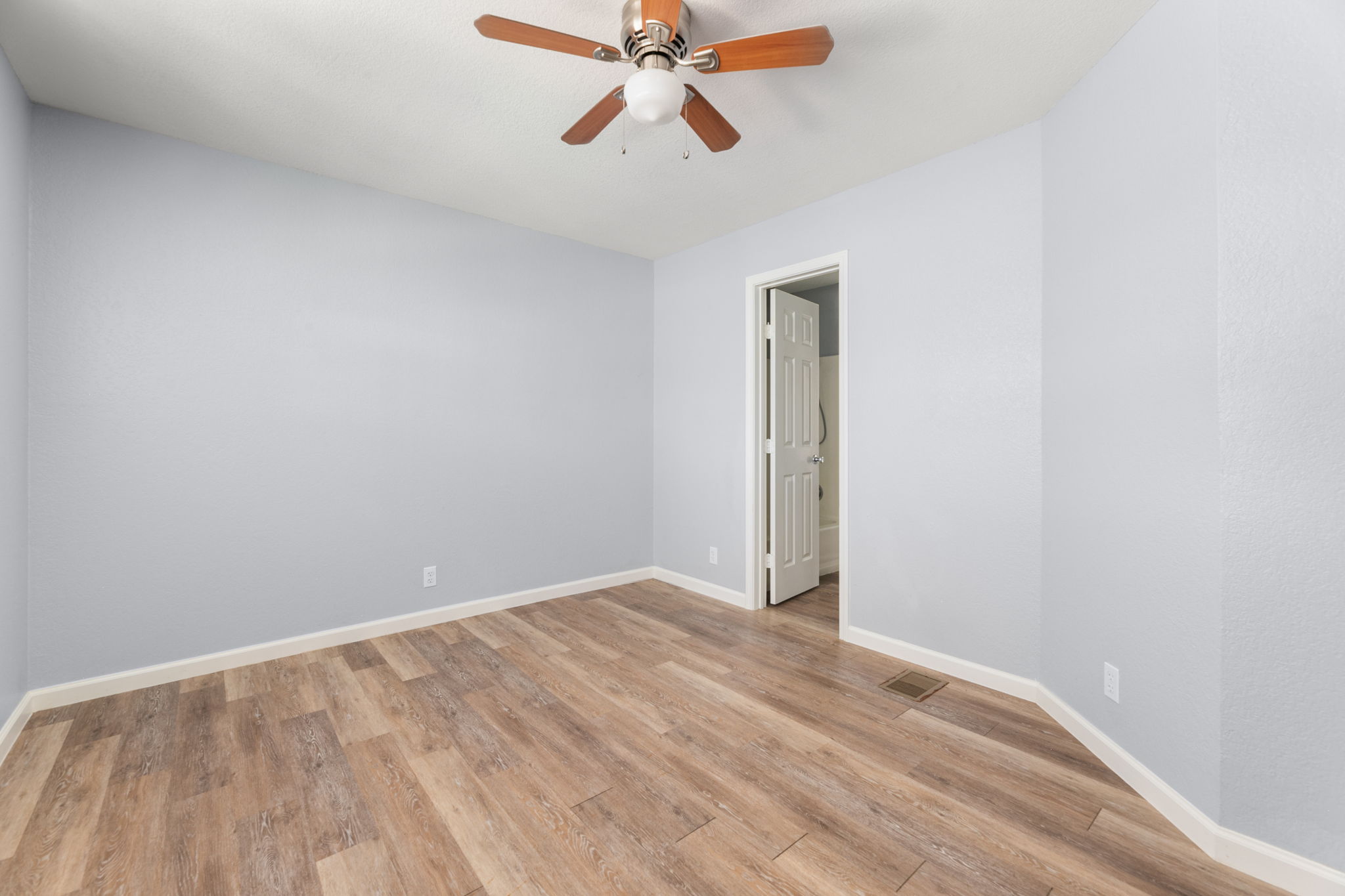 3802 Foust Trail, Unit A Georgetown, TX 78628 - Photo 22 of 34 A quiet bedroom featuring elegant wood-look flooring and a modern ceiling fan for year-round comfort.