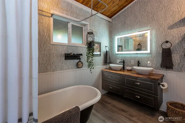 a bathroom with a tub sink and mirror