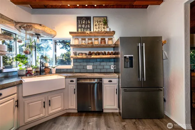 a kitchen with kitchen island a counter top space a sink and stainless steel appliances