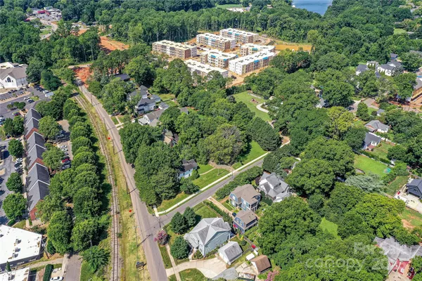 an aerial view of a residential houses with yard and green space